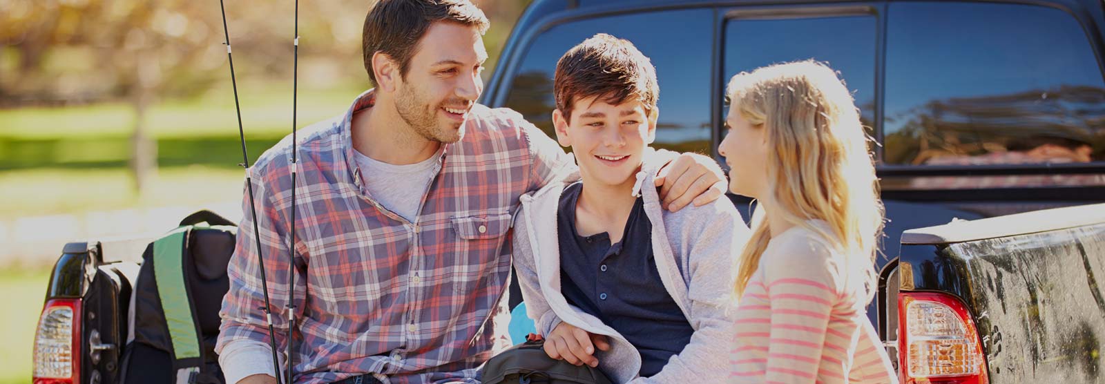 Father and kids in a pickup truck while on a fishing trip