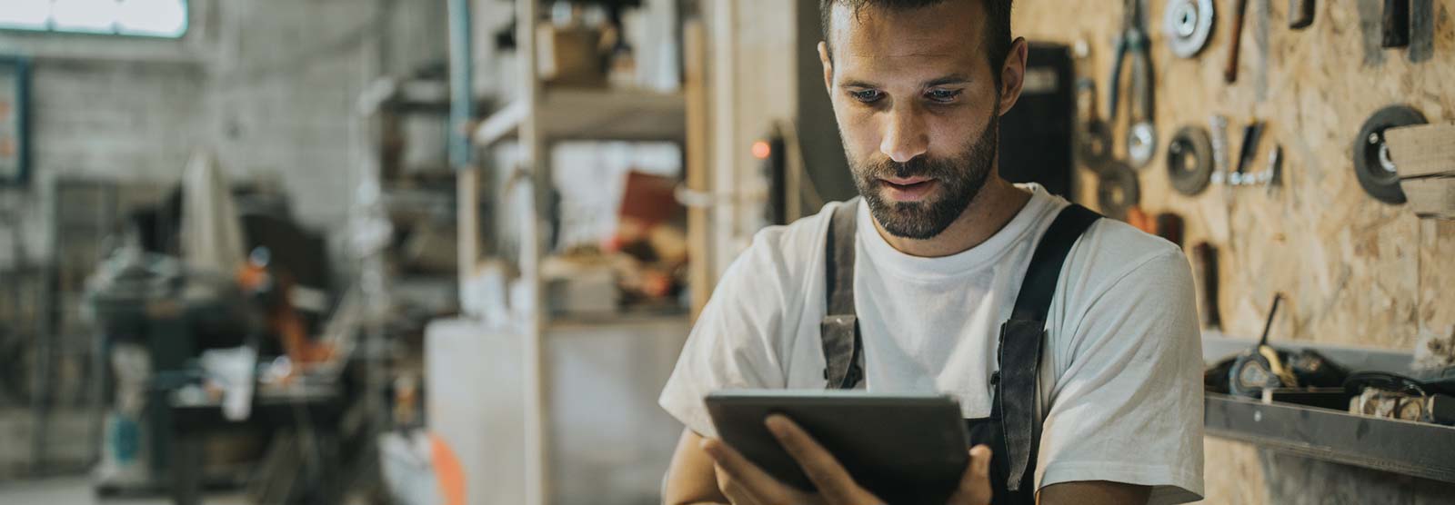 Man using a smart tablet in his shop